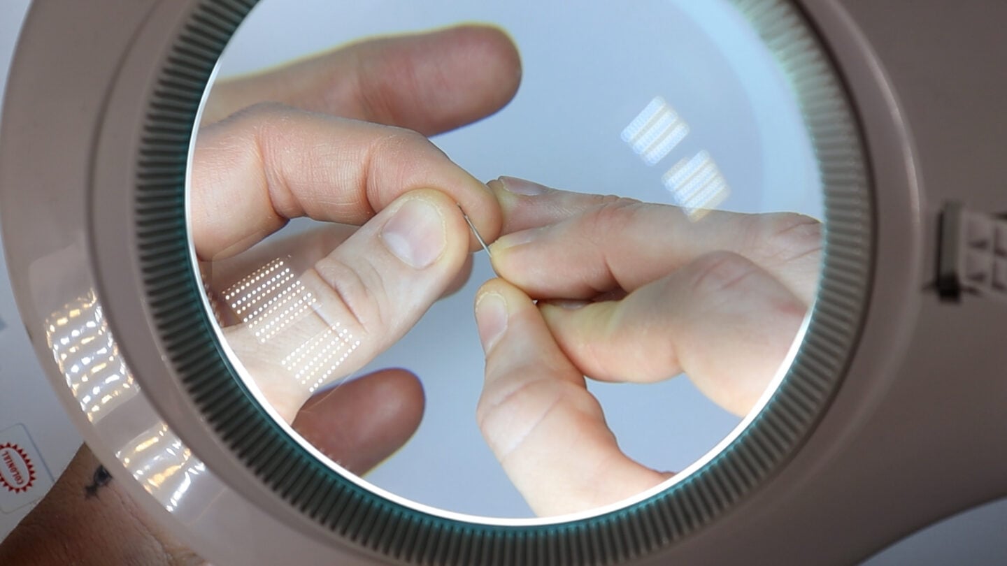 using a magnifying lamp to thread a needle