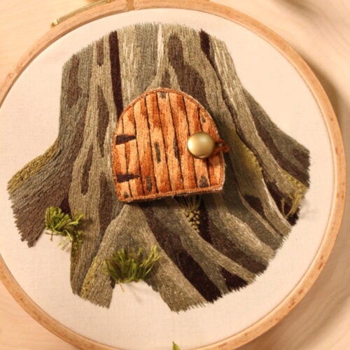 embroidery of a fairy door in a tree trunk
