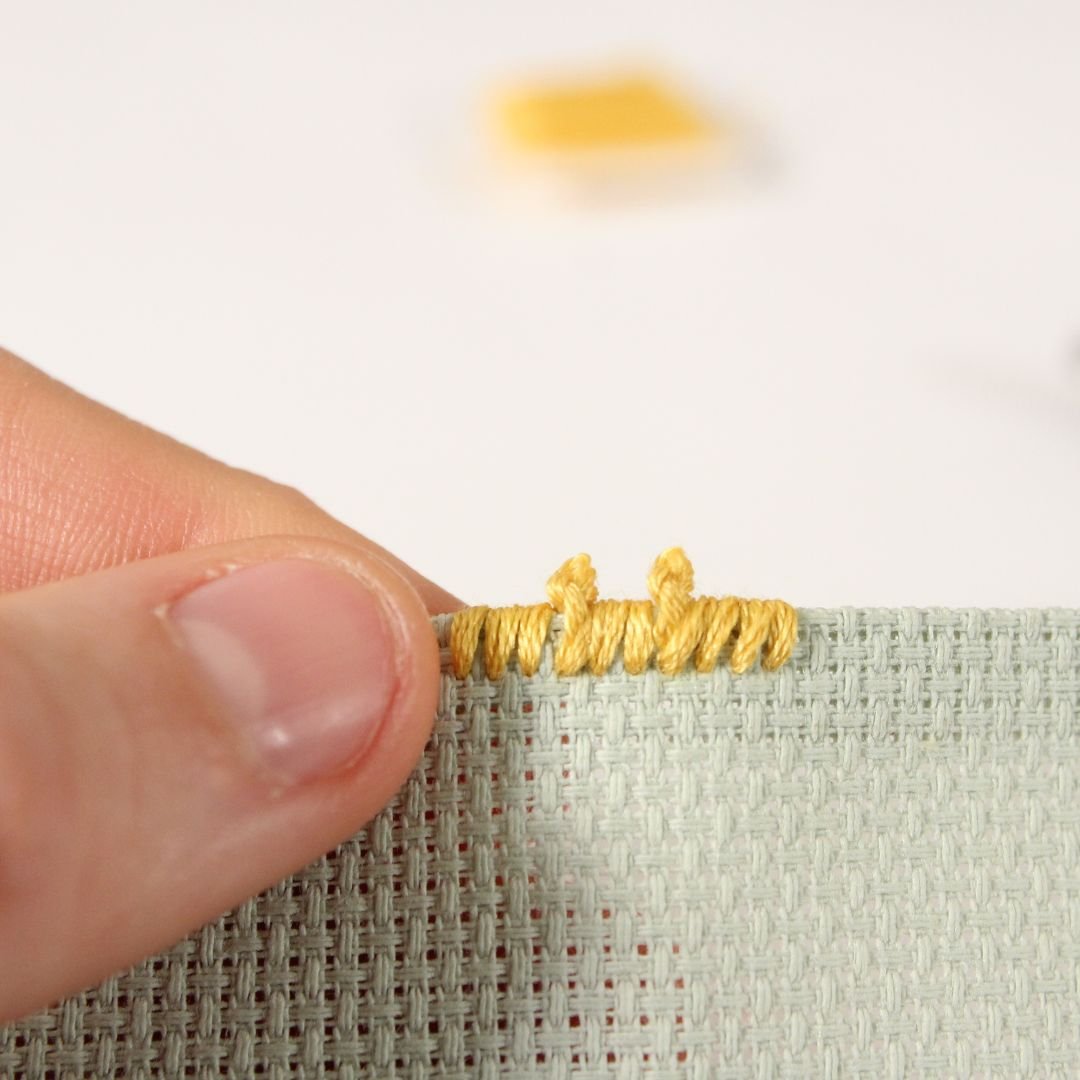 overcast picot edge on light green Aida fabric