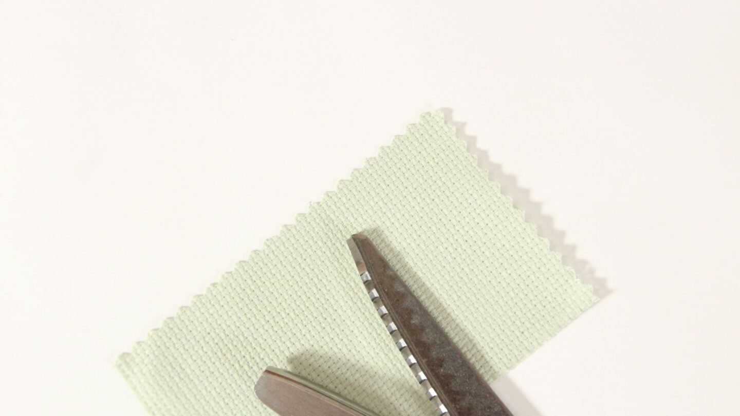 light green Aida fabric with zigzag edges trimmed with pinking shears