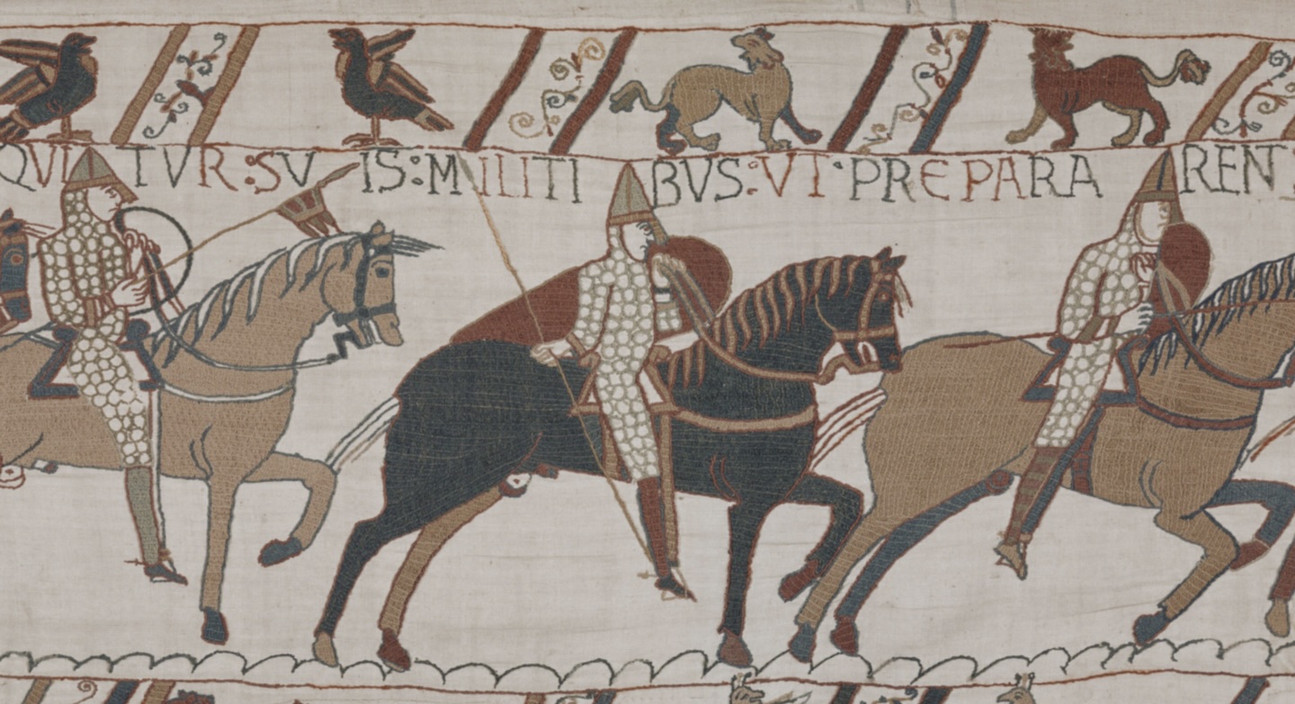 closeup portion of the Bayeux Tapestry with soldiers riding horses and an animal border with birds and lions