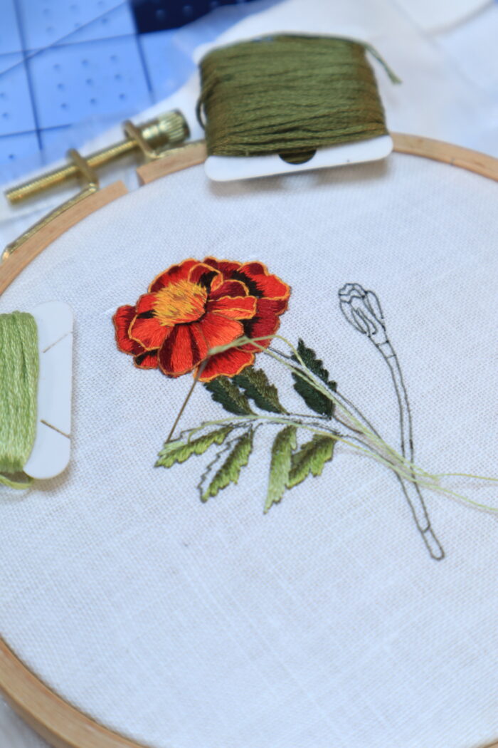close up of an embroidered red marigold flower